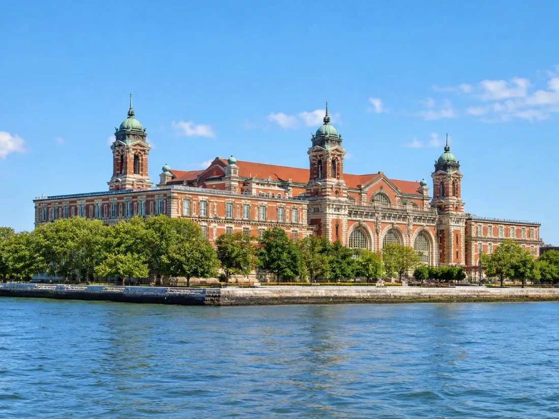 El edificio principal de ladrillo rojo de Ellis Island, con sus torres de cúpula de cobre, visto desde el agua